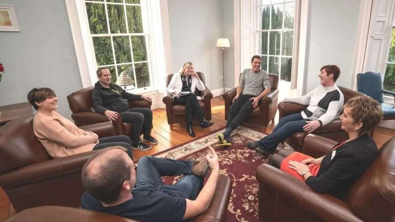 Seven people sat on leather chairs in a circle