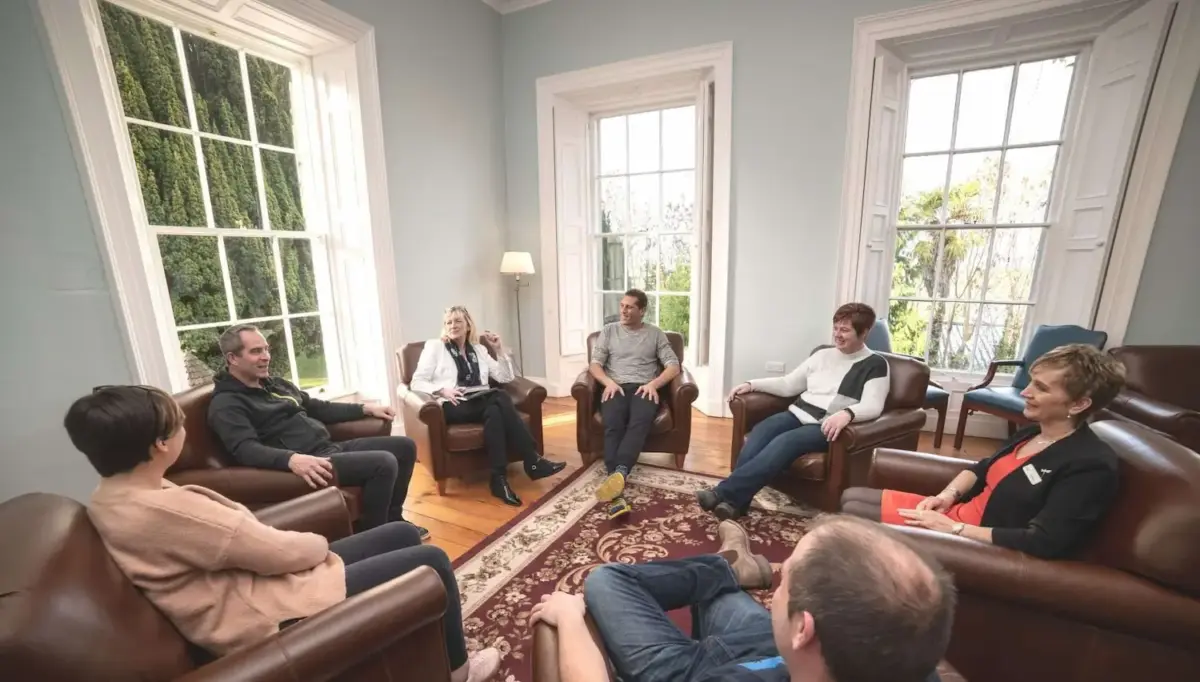Photograph of people sitting in a circle during addiction therapy at smarmore