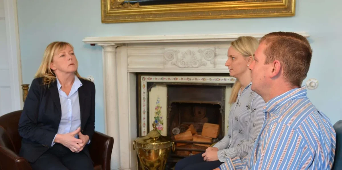 Two people sit across from an addiction therapist in conversation at Smarmore Castle