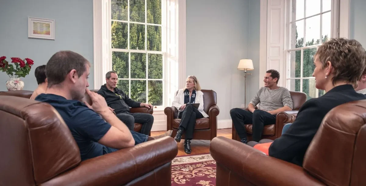 group therapy session at Smarmore Castle rehab clinic with people sitting in armchairs in a circle