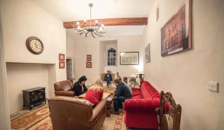 People sitting in armchairs and on a sofa around a coffee table, playing board games at Smarmore Castle while undergoing treatment for addiction