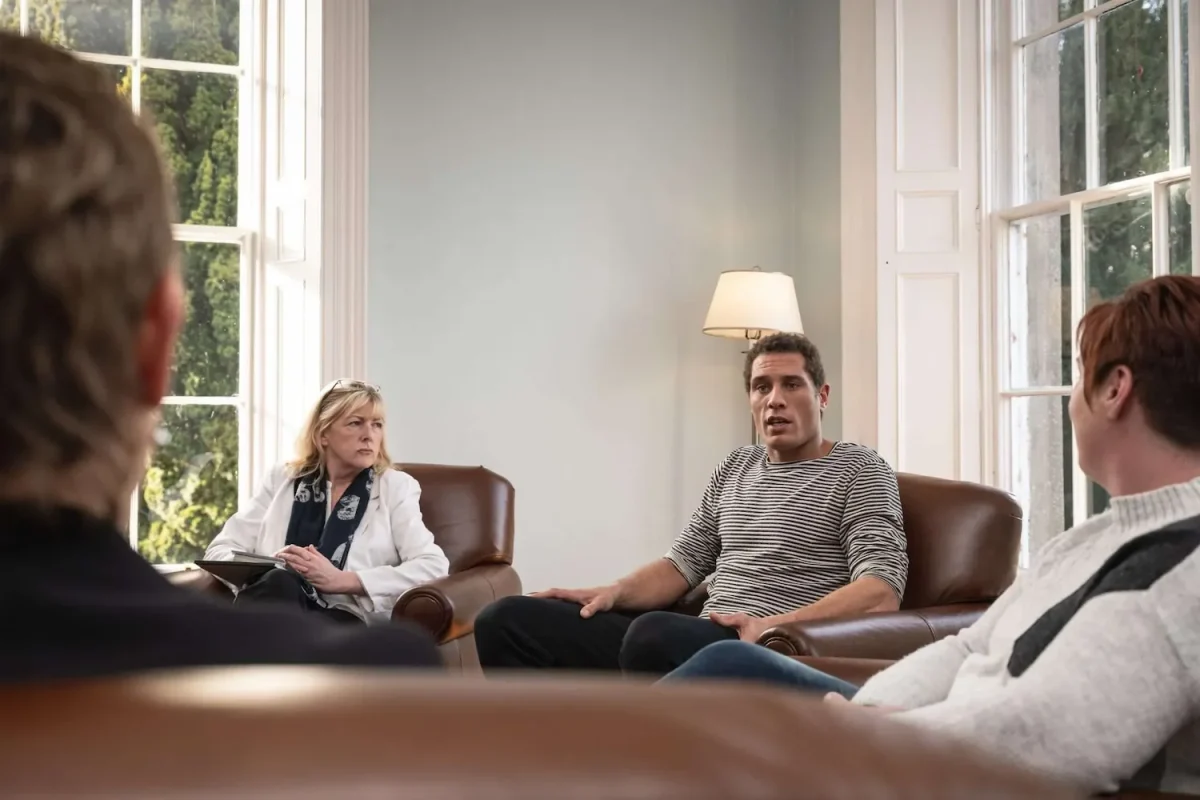 Indoor picture of people talking in a group therapy setting for addiction help
