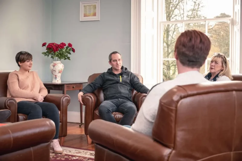 Addiction treatment in progress at Smarmore Castle, image showing four people sitting in chairs in a circle talking