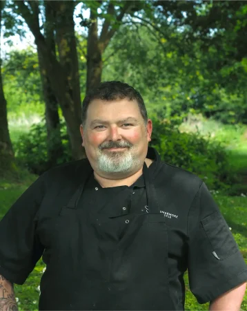 Portrait photo of Alan Greene, head chef at Smarmore Castle, photo taken outside with trees and greenery in background
