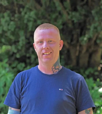 Portrait photo of David Heenery, recovery advocate at Smarmore Castle, photo taken outside against greenery