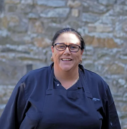 Portrait photo of Debbie Carolan, Chef at Smarmore Castle, photo taken outside against a stone wall background
