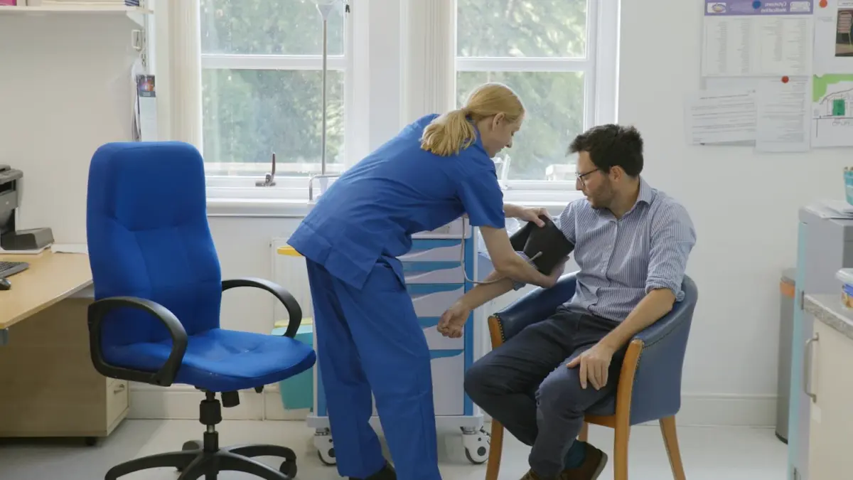 A nurse fits a blood pressure cuff to a patient during detox from alcohol and drugs at residential rehab whilst discussing cocaine detox.